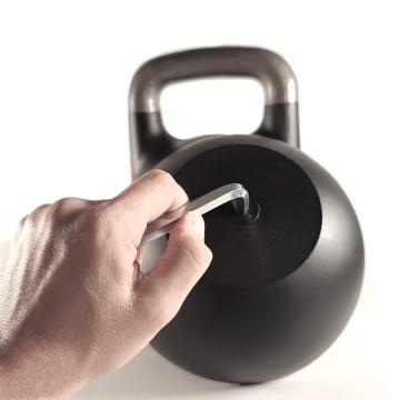 Il kettlebell componibile FlexiBell 2 in primo piano assieme ai dischi pesi inclusi