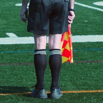 Guardalinee del calcio inquadrato di spalle, simbolo del rispetto delle regole nel 2023
