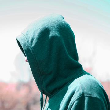 Ragazzo con cappuccio in anonimato, simbolo della stigmatizzazione del doping nel 2023