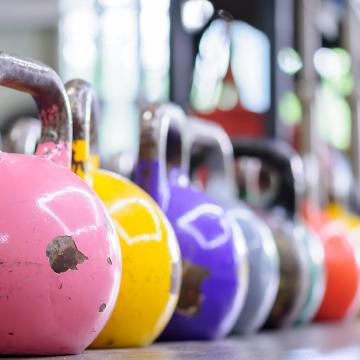 Kettlebell da competizione in primo piano con diversi pesi e colori per allenamento fitness.